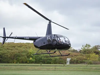 A helicopter takes off and hovers just above the ground.